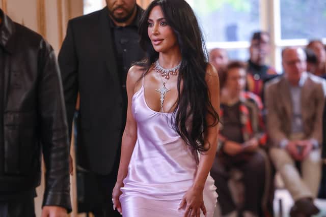 Sitting next to mum Kris Jenner on the front row, the 42-year-old American Horror Story actress accessorised her dress with a diamond necklace and a crucifix pendant.