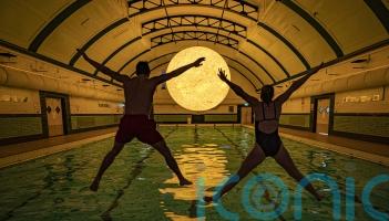 Sun artwork suspended above water at community swimming pool