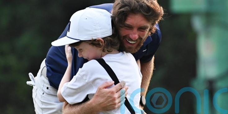 Tommy Fleetwood celebrates with son on 18th green after victory in Delhi