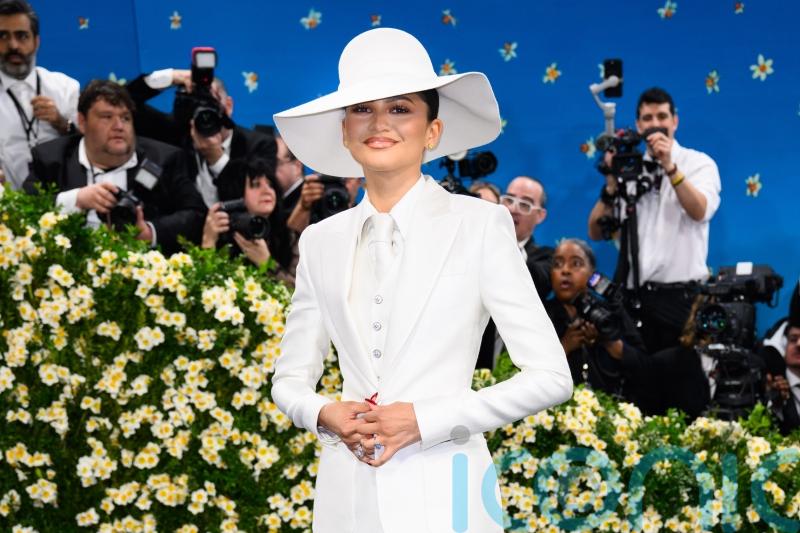 Zendaya sports gold band on her finger as she wears bridal white to fashion show